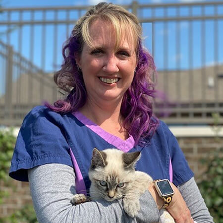 A woman holding a cat and smiling